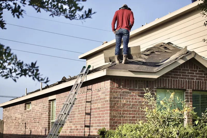 Professional roofer working on a residential roof in The Village